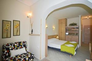 ein Schlafzimmer mit einem Bett und einem Stuhl in einem Zimmer in der Unterkunft Erodios Studios in Skala Kallirachis