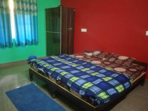 a bedroom with a bed with a blue comforter at Bhagwati home stacy in Lansdowne