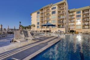 un hotel con piscina y sillas y un edificio en 2512 Villamare Penthouse Ocean View, en Hilton Head Island