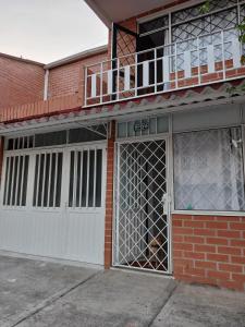 - un bâtiment en briques rouges avec une porte de garage blanche dans l'établissement Moderna casa Villavicencio, à Villavicencio