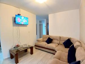 - un salon avec un canapé et une télévision dans l'établissement Moderna casa Villavicencio, à Villavicencio