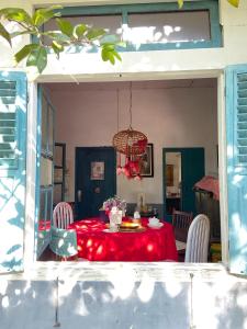 tavolo da pranzo con tovaglia rossa di Ruma Kaca Simanindo Bed&Breakfast ad Ambarita Altre 23 foto