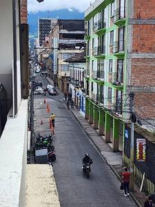 een persoon die op een motor door een straat rijdt bij Casa en el centro de la ciudad in Pasto