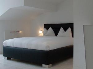 una camera da letto con un grande letto con lenzuola e cuscini bianchi di VISIONAPARTMENTS Freyastrasse - contactless check-in a Zurigo
