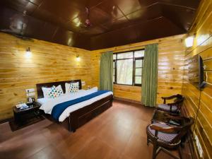a bedroom with a bed and a wooden wall at Pinewood Nirvana Jungle Resort Shoghi in Shimla