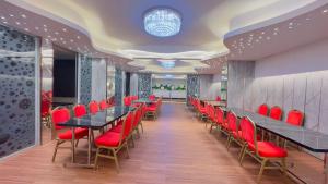 a conference room with red chairs and tables at Hotel Rose Garden Palace Residential in Dhaka