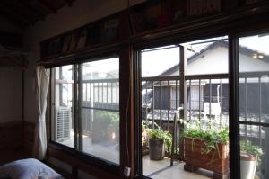 a room with two windows with plants on a balcony at 宿たぬきのねどこ GUESTHOUSE TANUKI in Tokoname