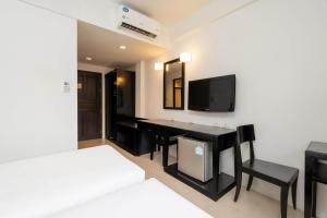 uma sala com uma mesa e cadeiras e uma televisão em PP Charlie Beach Resort em Phi Phi Don