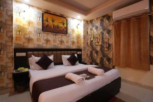 a bedroom with a large bed with towels on it at HOTEL DV PLAZA INN in New Delhi