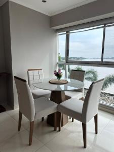 a dining room with a table and chairs and a window at Spacious 2 Bedroom Apartment with river views in Puerto Santa Ana River Front 2 in Guayaquil