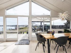 a dining room with a table and a large window at 5 star holiday home in Kolding in Kolding