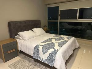 a bedroom with a bed and a large window at Spacious 2 Bedroom Apartment with river views in Puerto Santa Ana River Front 2 in Guayaquil