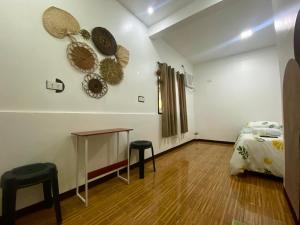 モアルボアルにあるTopBudz Hostel Panagsama Moalboal Coupleのベッド1台、テーブル、スツール2脚が備わる客室です。