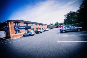 a parking lot with cars parked in front of a building at Travelodge Dublin Airport North 'Swords' in Swords