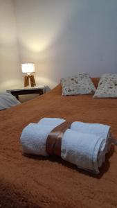 Una cama con dos toallas encima. en HOSPEDAJE " La Catalina " Ubicada a 15 minutos del Aeropuerto Internacional de Ezeiza con Estacionamiento en Tristán Suárez