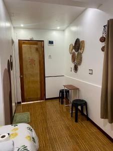 Camera con porta, tavolo e frigorifero. di TopBudz Hostel Panagsama Moalboal Couple a Moalboal