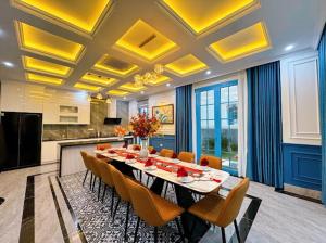 une grande salle à manger avec une longue table et des chaises dans l'établissement Villa - Biệt Thự Nghĩ Dưỡng Hạ Long, à Hạ Long