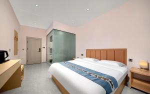 a bedroom with a large white bed in a room at Yuge Hotel - Harbin Taiping Airport in Harbin