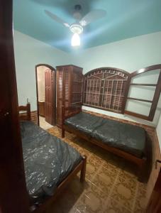 a room with two beds and a ceiling at Recanto da Alegria in Saquarema