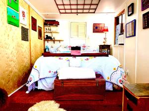 Sedona Camp Tiny House في سيدونا: غرفة نوم بسرير ولحاف ابيض