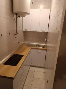 a small kitchen with white cabinets and a sink at Apartments Ante - seaview in Brela