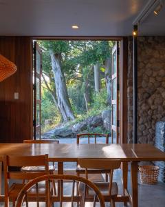 ein Esszimmer mit einem Holztisch und Stühlen in der Unterkunft kamenos Luxury Resort With Beautiful Scenery Hiji in Hiji