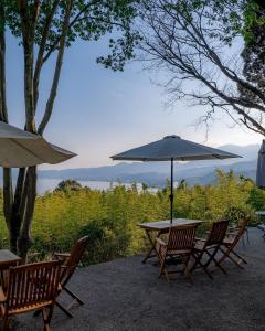 een tafel en stoelen met een parasol bij kamenos Luxury Resort With Beautiful Scenery Hiji in Hiji