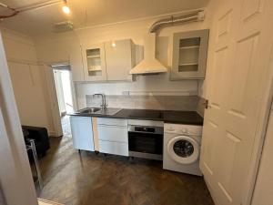 a kitchen with a sink and a washing machine at The Hyde Arms in Edmonton