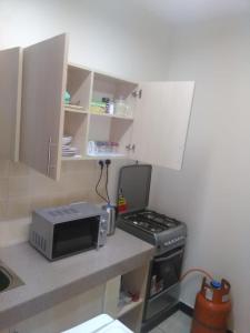 a small kitchen with a stove and a microwave at Palace Hotel in Mbarara