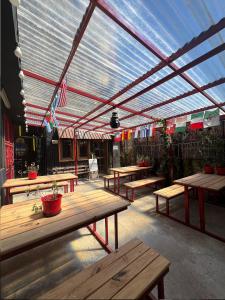 a patio with wooden picnic tables and awning at Atlantida Hotel in Río Grande