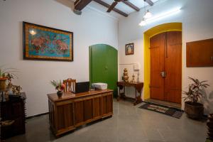 a room with a desk and a green door at Luigi Villa in Puducherry