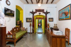 ein Wohnzimmer mit Möbeln und einer gelben Tür in der Unterkunft Luigi Villa in Puducherry