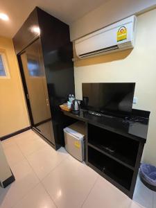 una pequeña cocina con encimera negra y TV en The Elegant Patong, en Patong Beach