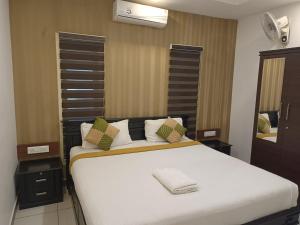 ein Schlafzimmer mit einem großen weißen Bett mit grünen Kissen in der Unterkunft Natural king Queen residency in Sultan Bathery