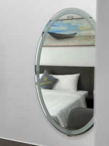 a mirror on a wall next to a bed at Sand Hotel in Cat Ba