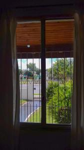 una ventana con vistas a una calle a través de ella en HOSPEDAJE " La Catalina " Ubicada a 15 minutos del Aeropuerto Internacional de Ezeiza con Estacionamiento en Tristán Suárez