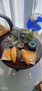 uma mesa com um prato de comida para o pequeno almoço em The Dragon Villa Hoi An em Hoi An