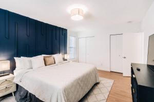 1 dormitorio con 1 cama grande y pared azul en Bright, chic & spacious in the heart of St. Paul by Summit-University with porch and swing chairs en Saint Paul