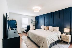 1 dormitorio con cama y pared azul en Bright, chic & spacious in the heart of St. Paul by Summit-University with porch and swing chairs en Saint Paul