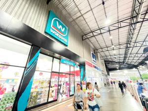 two people walking inside of a store at Lovely Impact C3-C9 Lily in Nonthaburi