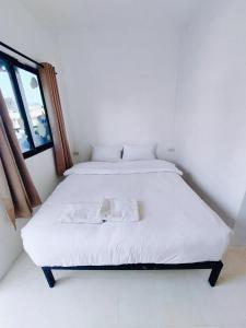 a white bed in a room with a window at BAO Phuket Pathong Beach in Patong Beach