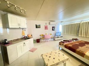 a room with a bed and a kitchen with a table at Lovely Impact C3-C9 Lily in Nonthaburi