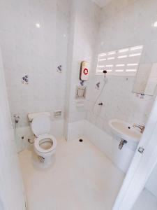 a white bathroom with a toilet and a sink at BAO Phuket Pathong Beach in Patong Beach