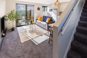sala de estar con sofá y escalera en Luxury Without Limits in CBD Christchurch, en Christchurch