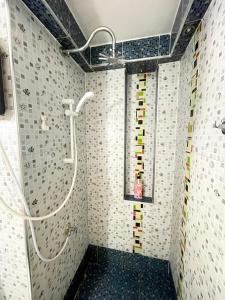 a bathroom with a shower with mosaic tiles on the wall at Lovely Impact C3-C9 Lily in Nonthaburi