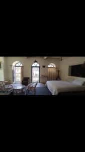 een slaapkamer met een bed en twee tafels en twee ramen bij Newari homestay in Pātan