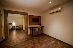 una habitación de hotel con TV y una habitación con cama en Hotel Colonial Hermosillo en Hermosillo