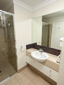 La salle de bains est pourvue d'un lavabo et d'une douche. dans l'établissement Rockingham Waterfront at Nautilus, à Rockingham