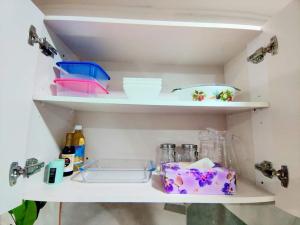 a kitchen shelf with dishes and other kitchen utensils at Studio at Berry Road in Suva