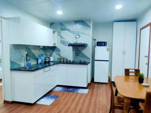 a kitchen with white cabinets and a wooden table at Studio at Berry Road in Suva